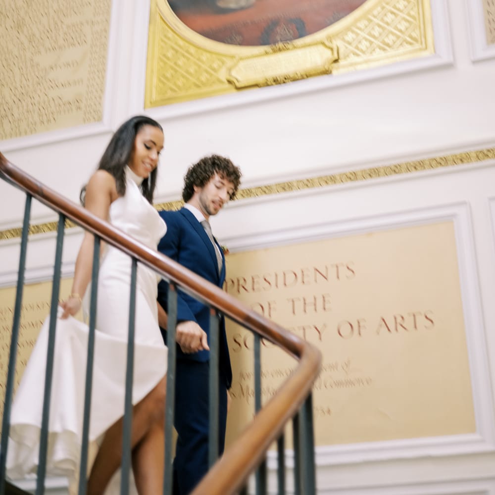 Bride & groom walk down staircase together