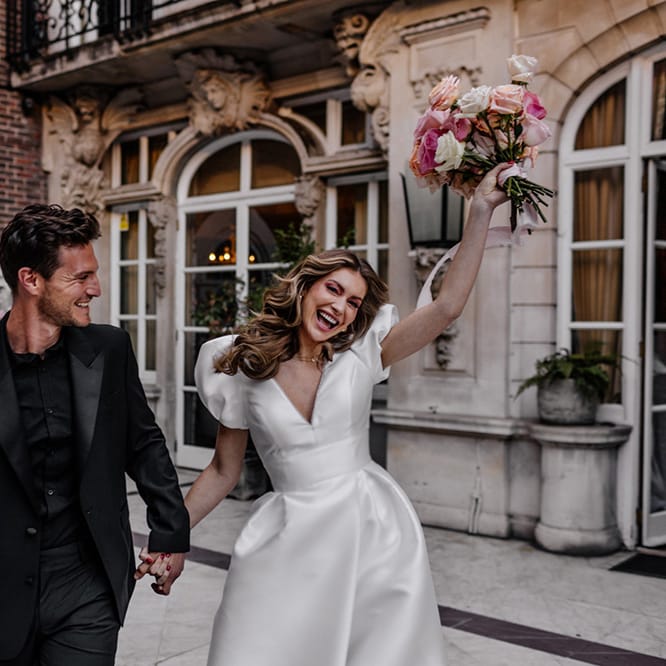 Happy bride and groom in a black suit and princess wedding dress at their intimate luxury wedding in London 