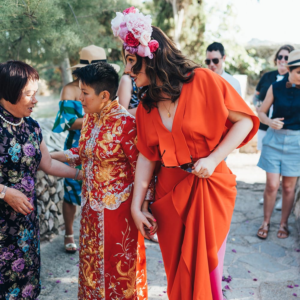 Brides walk together in traditional Chinese dress and red wedding gown