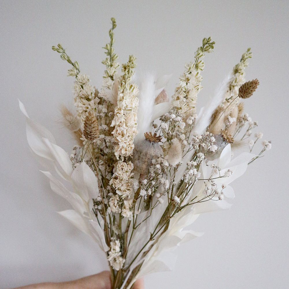 Hand holding muted dried flower bouquet