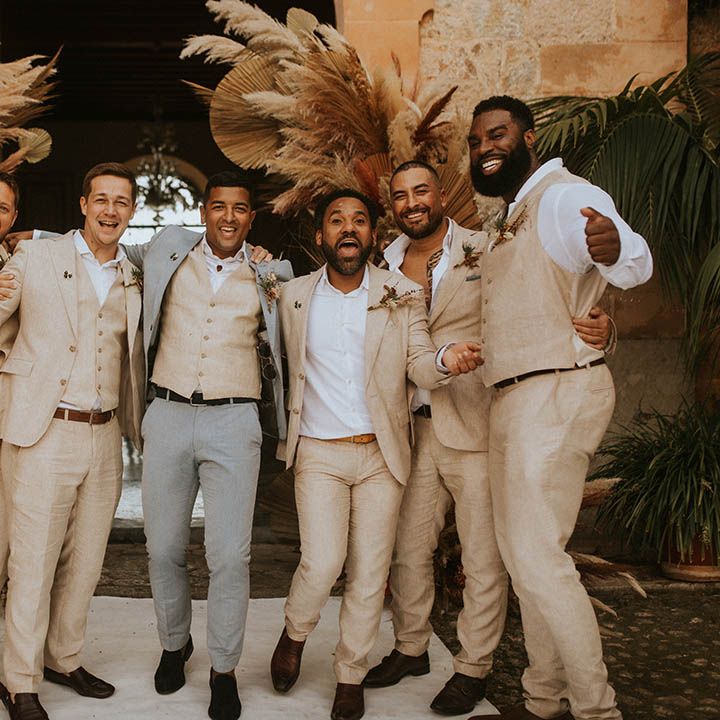 Groom stands with his groomsmen who wear sandy coloured suits and white shirts