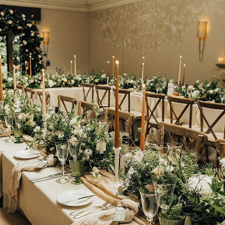 Elegant wedding reception flowers and decor at Foxhill Manor with taper candles and foliage flowers and floral arch 
