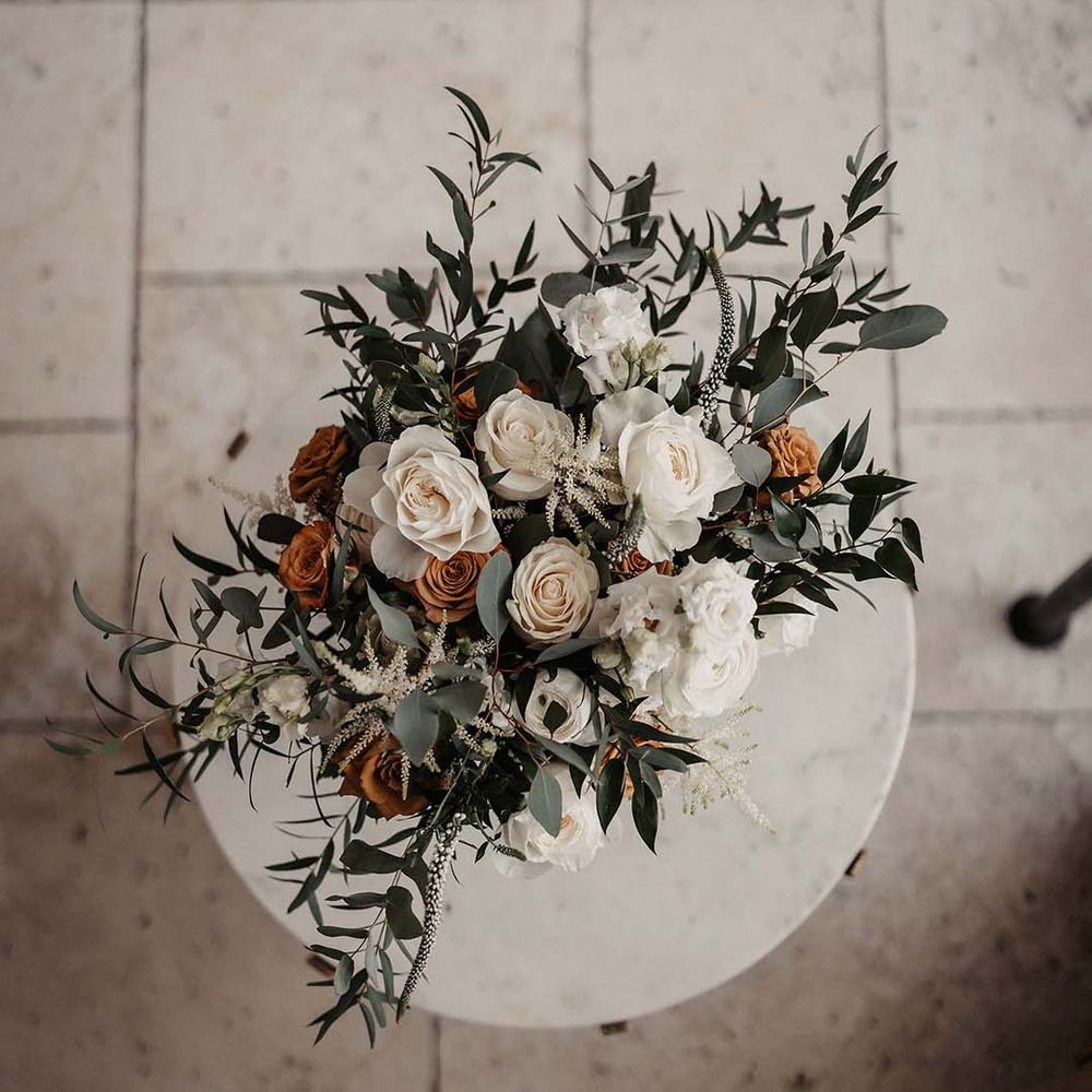 Wedding flowers with white and orange roses and greenery for earth toned spring wedding