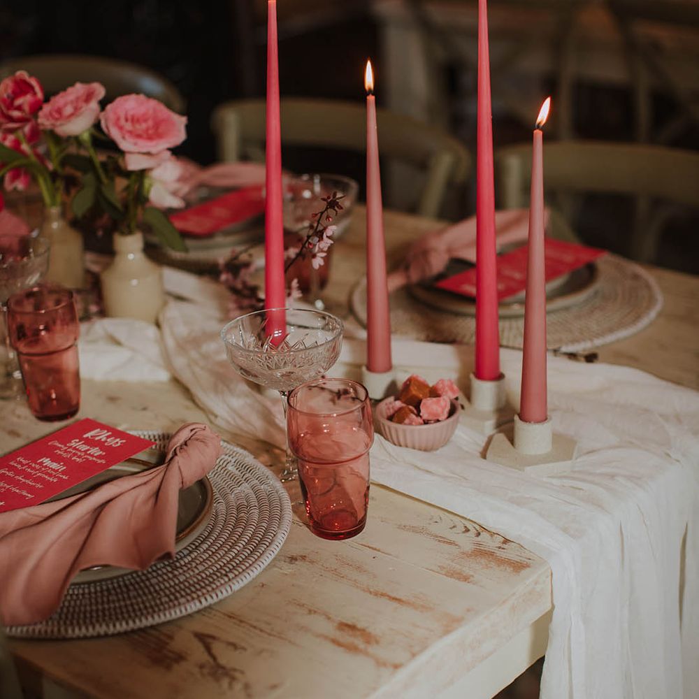 wedding table decor with cream table runner, wicker place mat, pink taper candles and pink on the day wedding stationery menu card