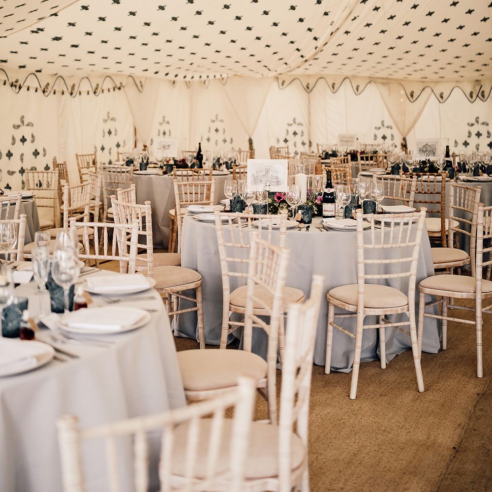 Marquee wedding reception with blue colour scheme including a blue tablecloth and blue glassware 