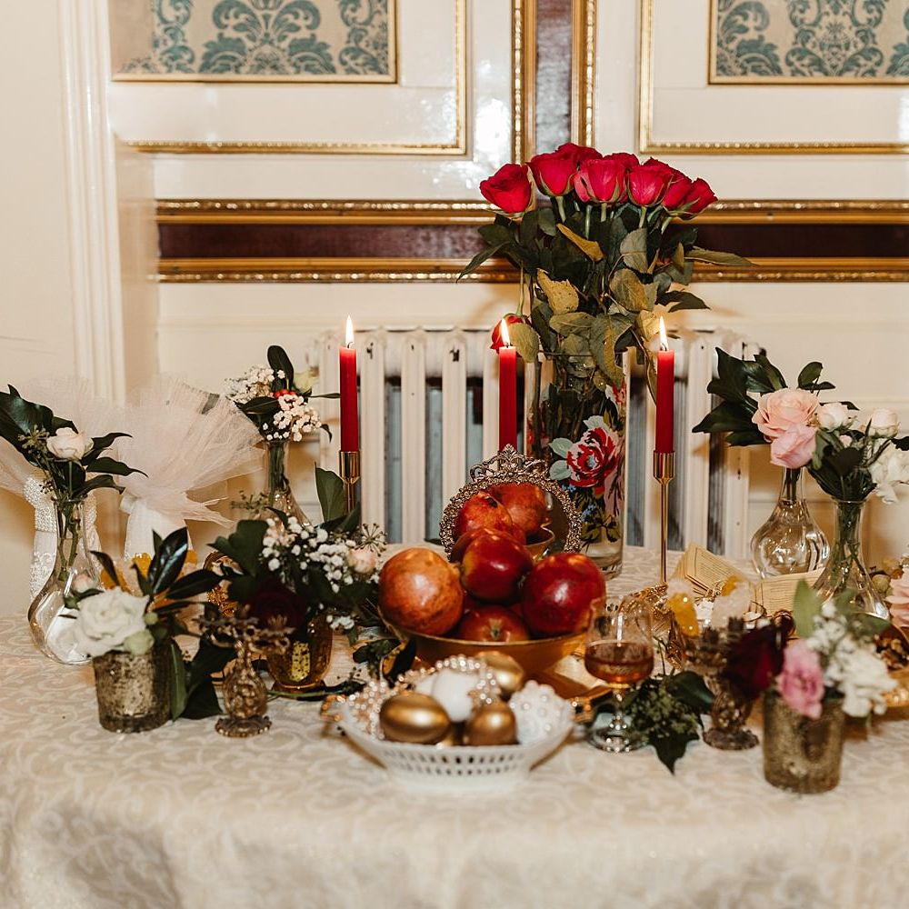 Sofreh Aghd table complete with red roses and symbolic items representing blessings for the couples married life together
