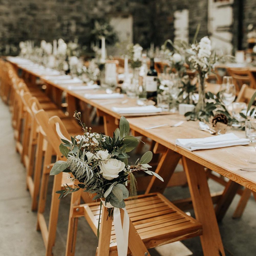 Neutral themed wedding tablescape with foliage decorations and fairy lights at Plas Dinam wedding venue