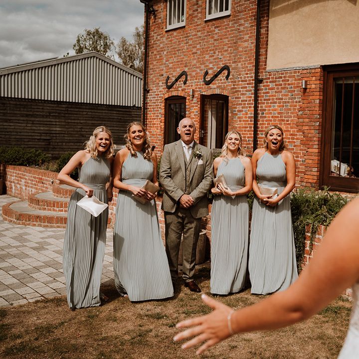 The father of the bride and the bridesmaids get their first look at the bride in her Christina K wedding dress 