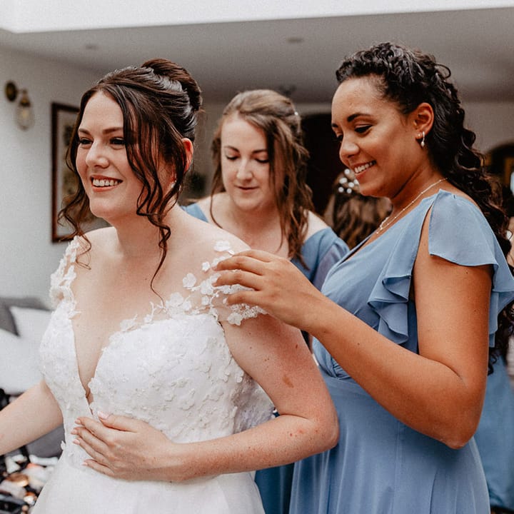 Bride in Suzanne Neville wedding dress with flower design with the bridesmaids in cornflower blue bridesmaid dresses 