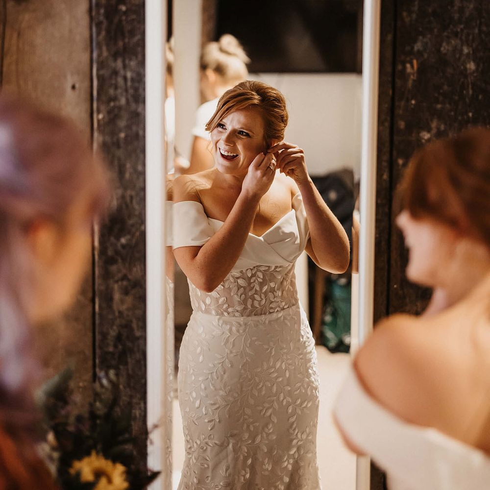 Bride wears appliqué Love Spell wedding dress with off the shoulder design and sheer bodice 