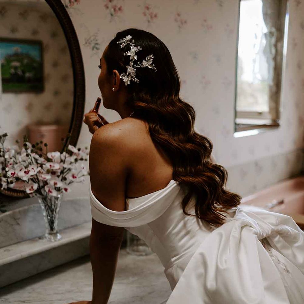 Bride in a strapless wedding dress with long wedding hairstyle, finger waves and sparkly hair accessory 