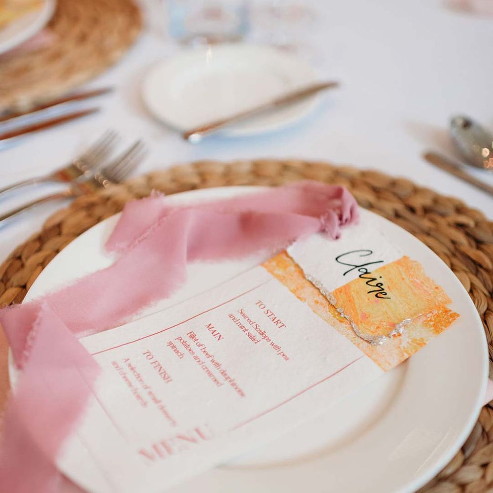Seasonal flower inspired wedding menu with pink frayed ribbon on burlap wedding place mat at Merriscourt wedding 