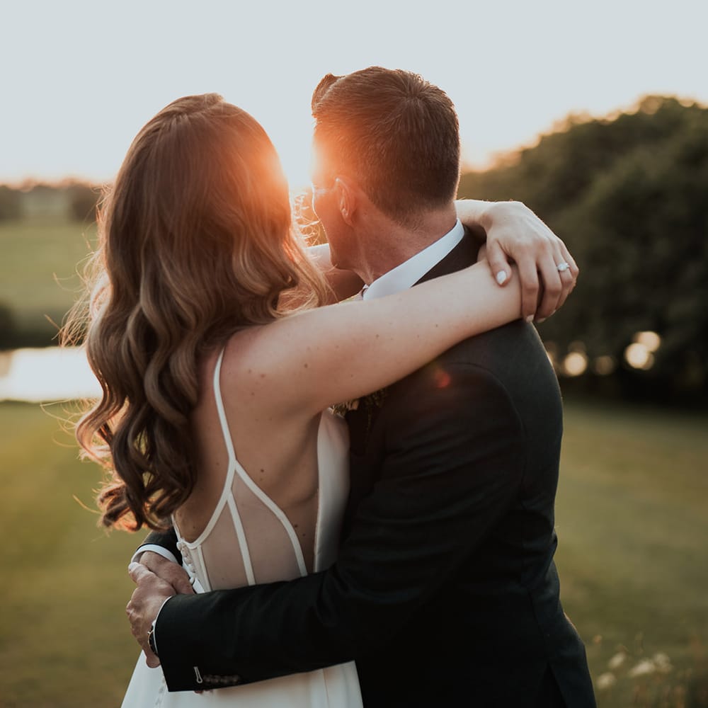 Golden hour wedding photo of the bride and groom looking out at the view 