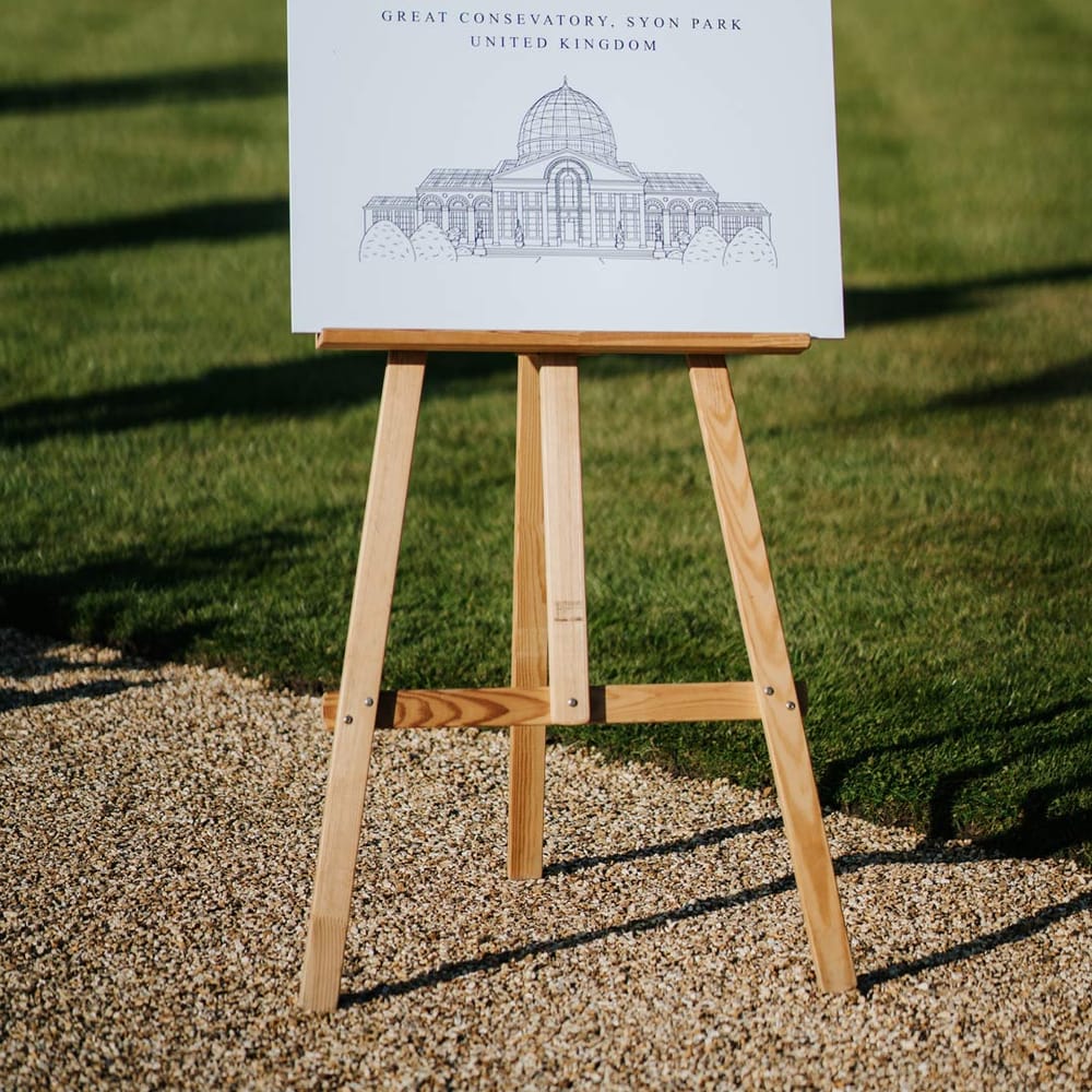 Minimalist monochrome wedding welcome sign on wooden easel at Syon Park wedding venue
