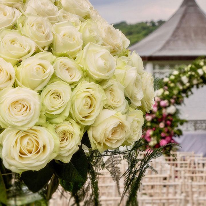 Stunning white rose wedding flower arrangement looking out over at the gazebo for outdoor ceremonies 