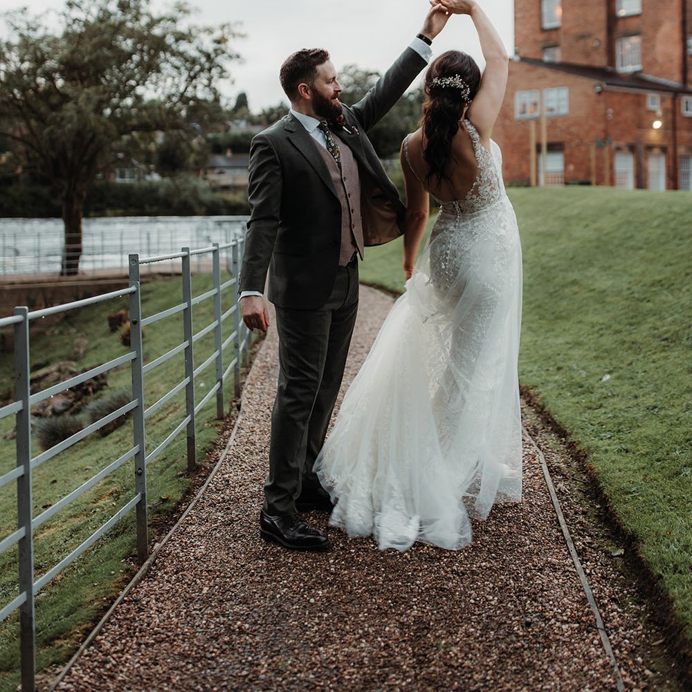 The groom in a green wedding suit dances with the bride at Derbyshire wedding 