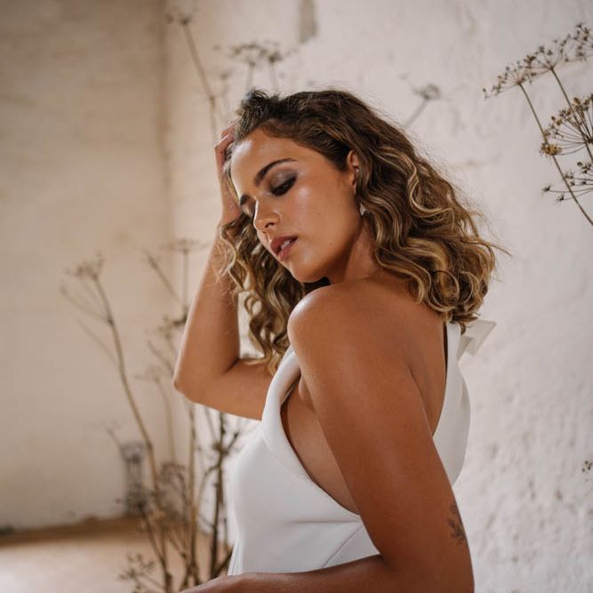 Bride in one shoulder jumpsuit with curly hair 