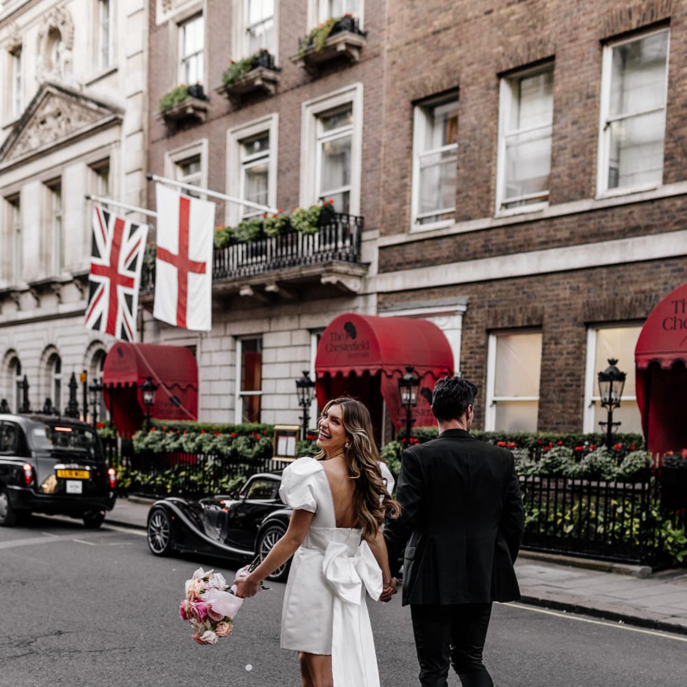 Stylish short wedding dress for city wedding with puff sleeves, low back and trailing bow detail