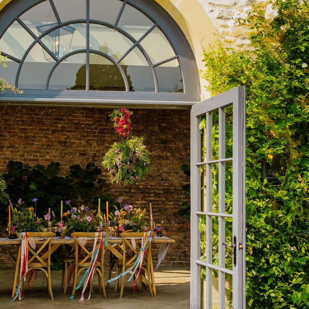 Fiesta theme wedding table decor with colourful ribbons, wildflowers and hanging baskets 