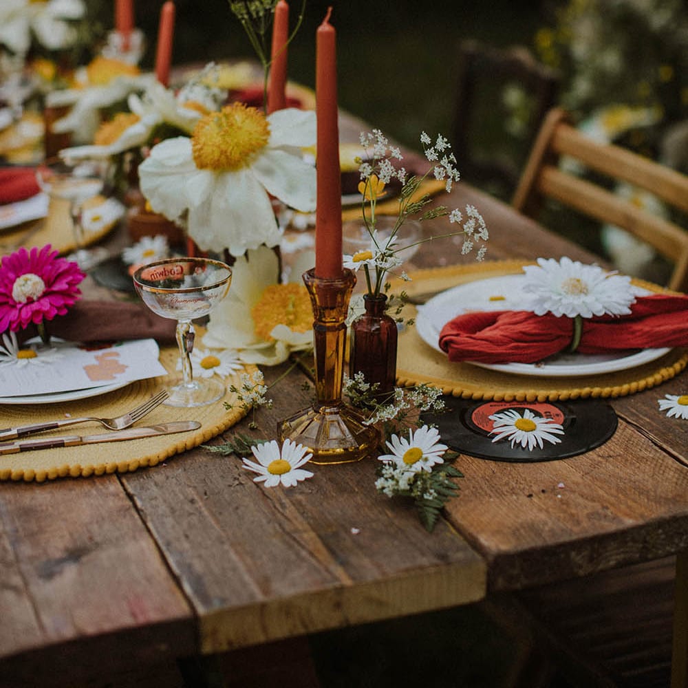 wedding table decor with brown candlestick holders, taper candles, wildflowers and yellow place mats 