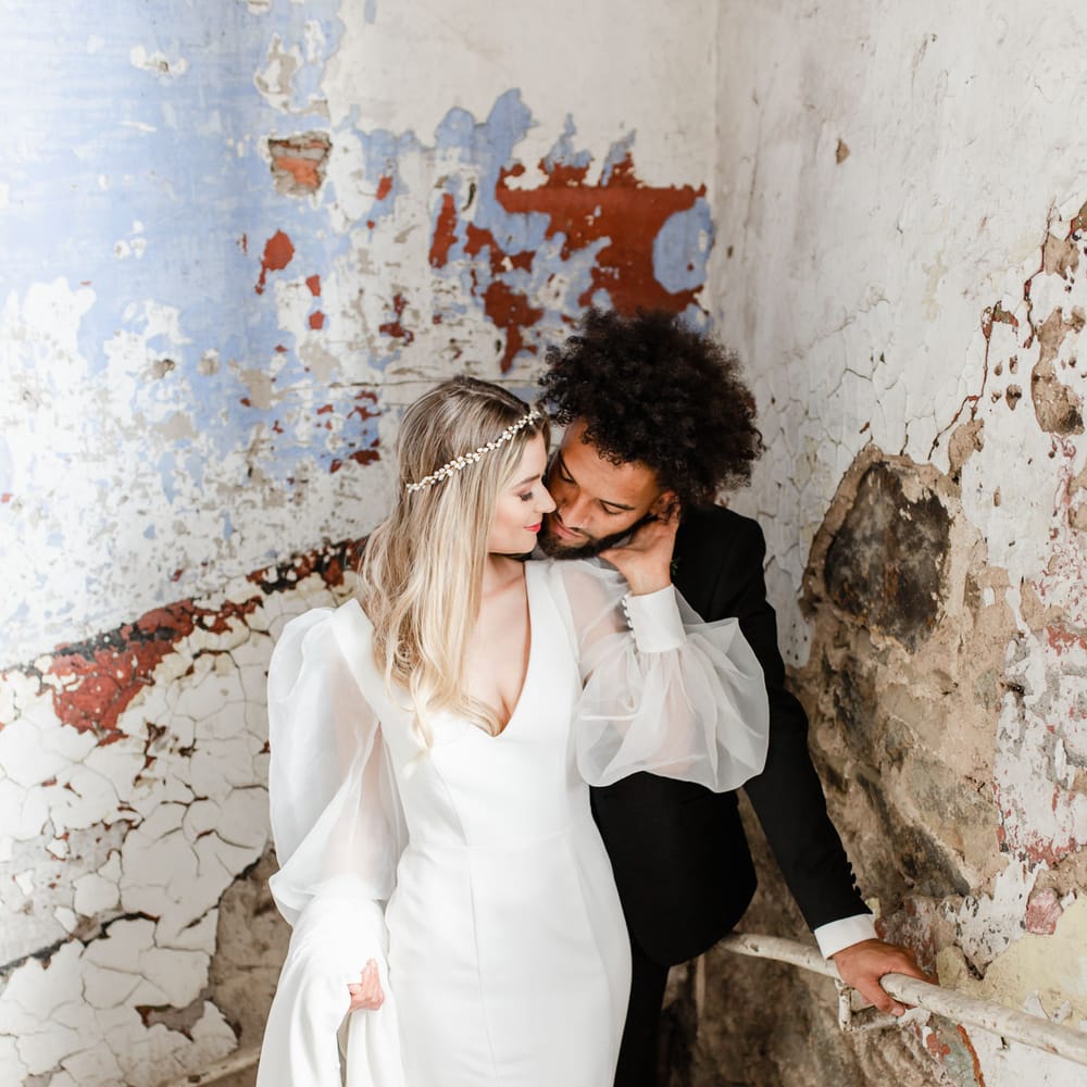 Bride and groom portrait in the stairwell at Torr Vale Mill industrial wedding venue with flakey walls 