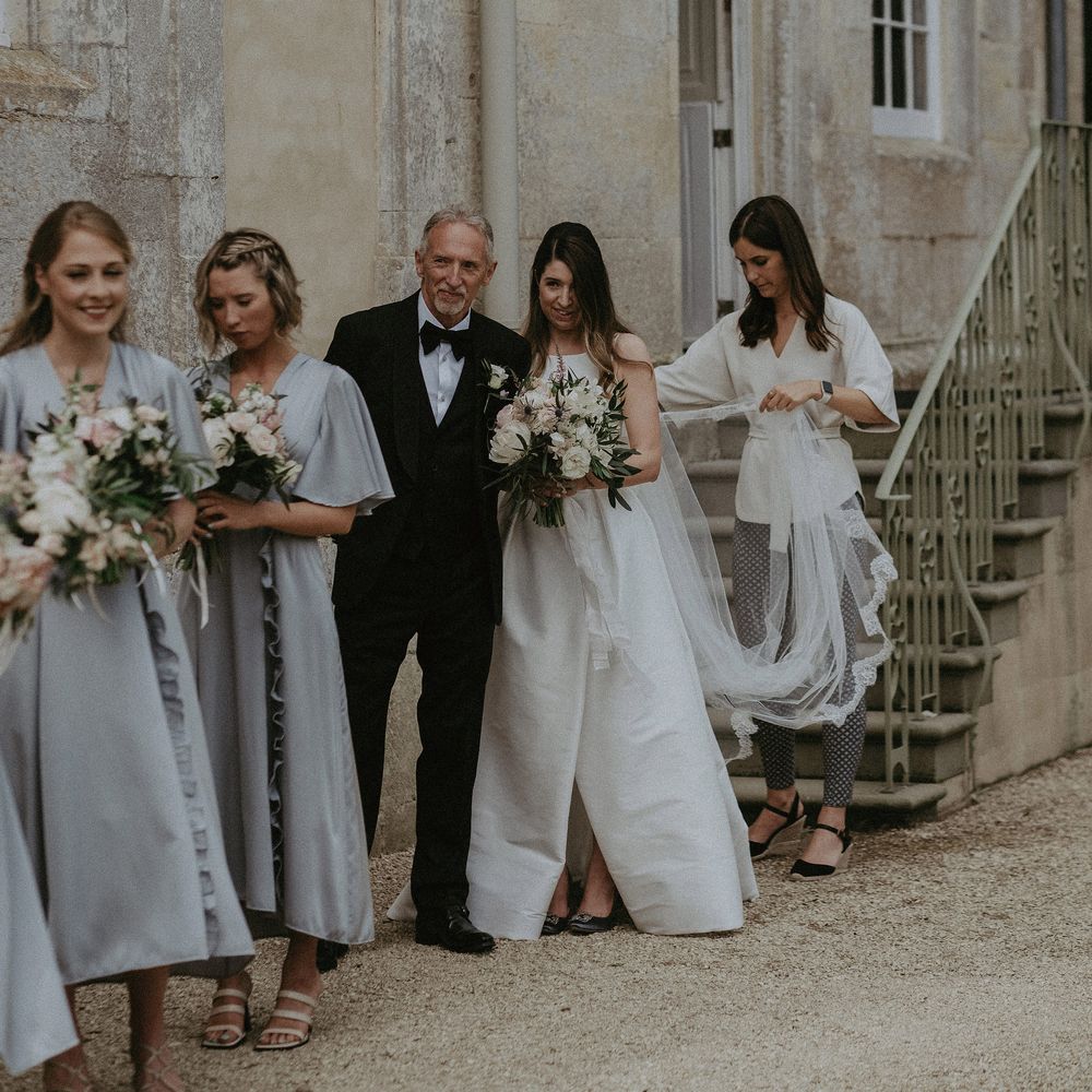 Bride lines up with bridesmaids before walk down the aisle at Elmore Court