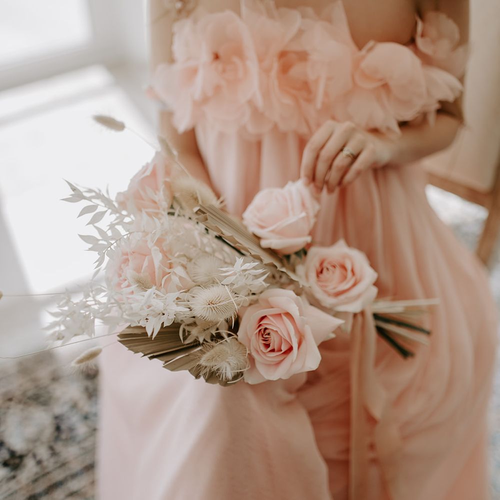Dried and fresh flower wedding bouquet with pink roses and neutral dried palm leaves 