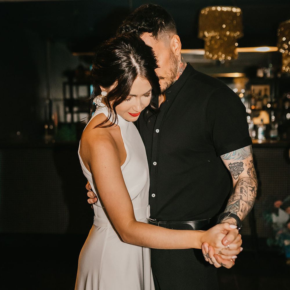 First dance with groom in a black short sleeve shirt and bride in a halterneck wedding dress with red lipstick 