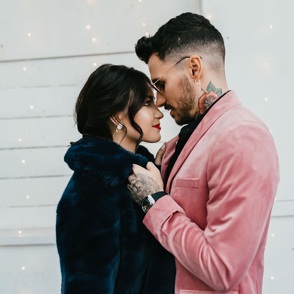 Intimate bride and groom portrait with the groom in a pink velvet jacket and the bride a navy blue faux fur bridal cover up 
