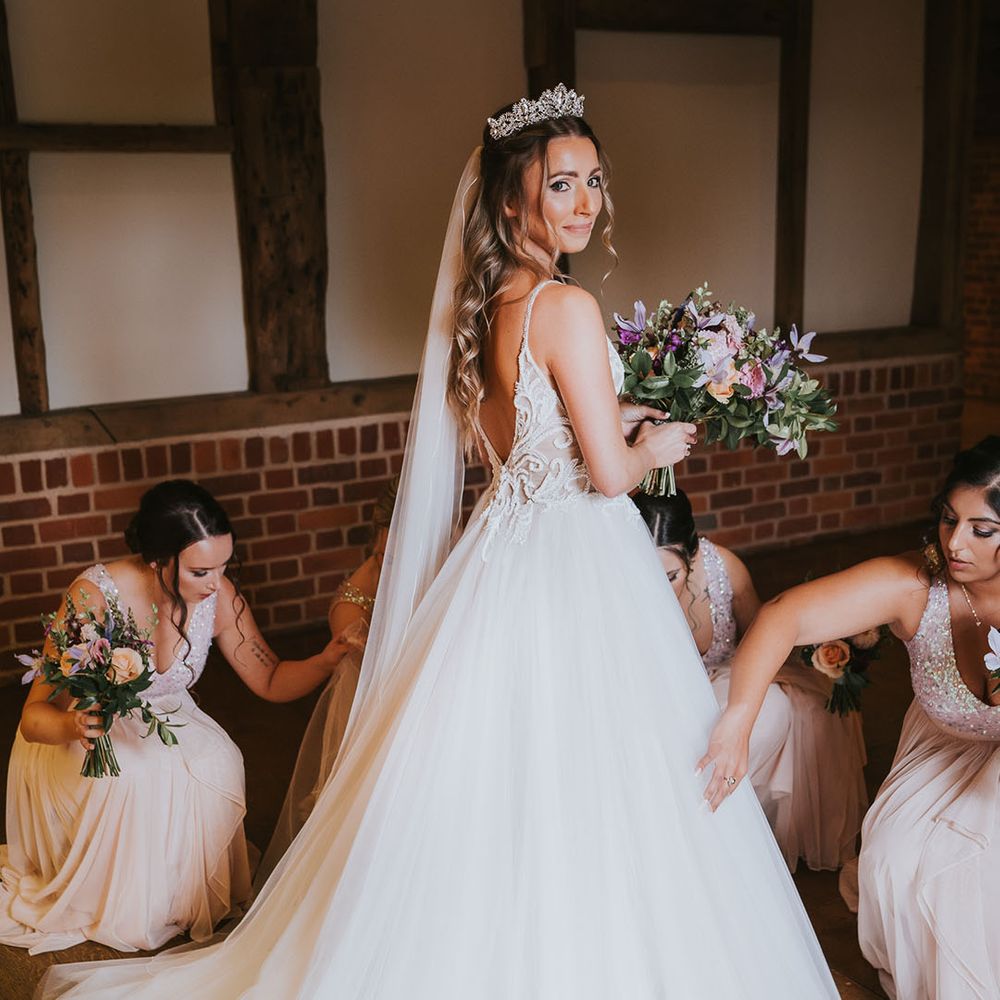 Bride in tulle skirt wedding dress with puddle train and veil with silver tiara and deep v cut back 