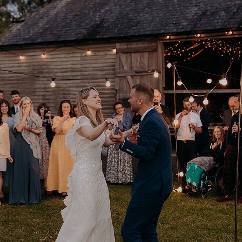 Rustic barn wedding with bride in a sparkly Eliza Jane Howell wedding dress at outdoor first dance 