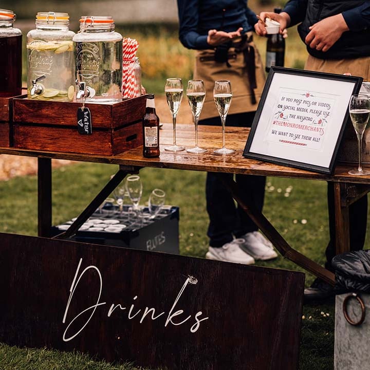 Outdoor wedding drinks station with alcoholic and non alcoholic drink options 
