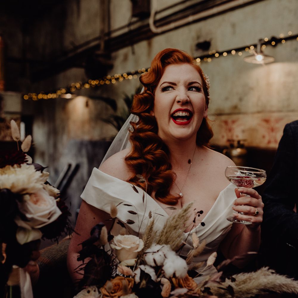 Bride with red vintage wedding hair drinking champagne 