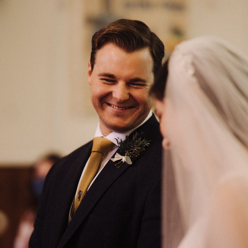 Groom smiles at bride on wedding day