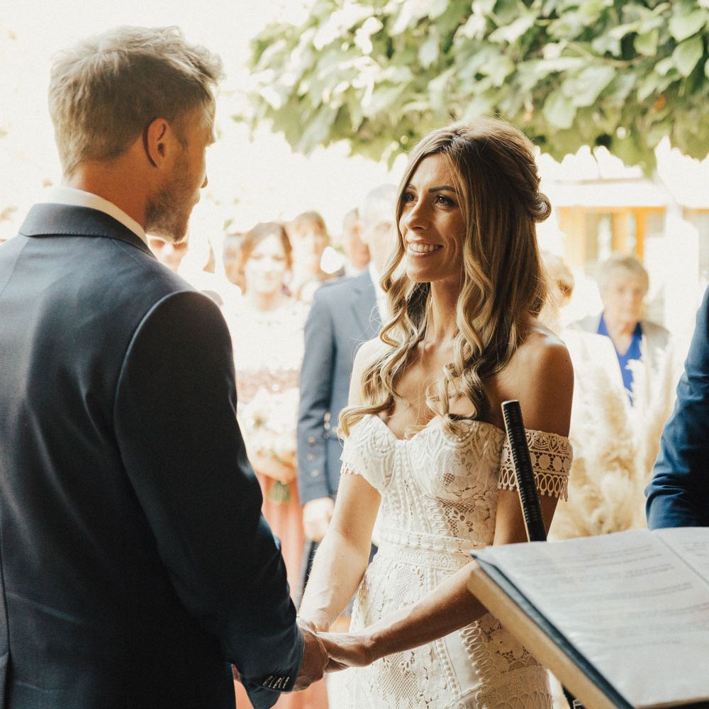 Bride and groom hold hands during marriage ceremony
