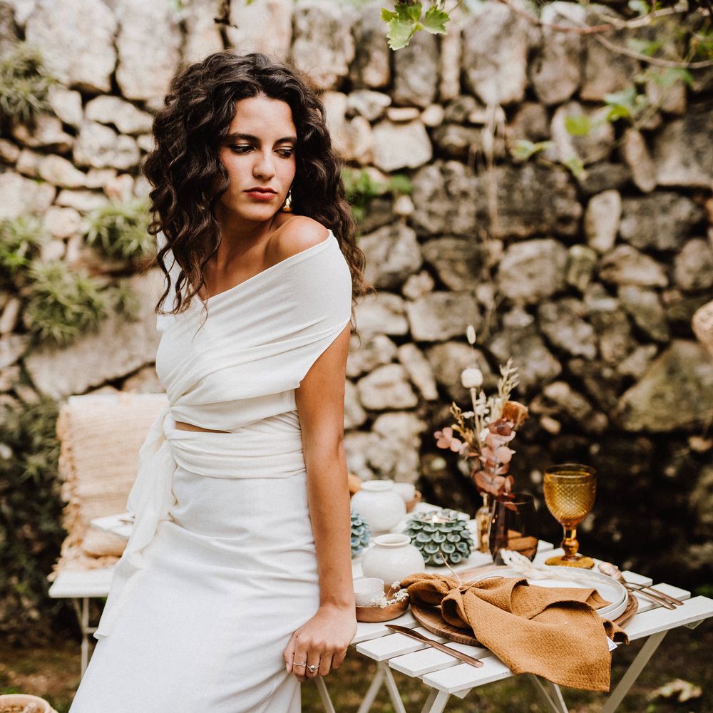 Boho bride with 80s style crimped hair and golden statement earrings