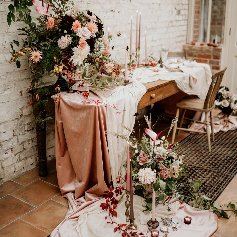 Wedding table decor with velvet tablecloth and blush pink and green wedding flower arrangements 