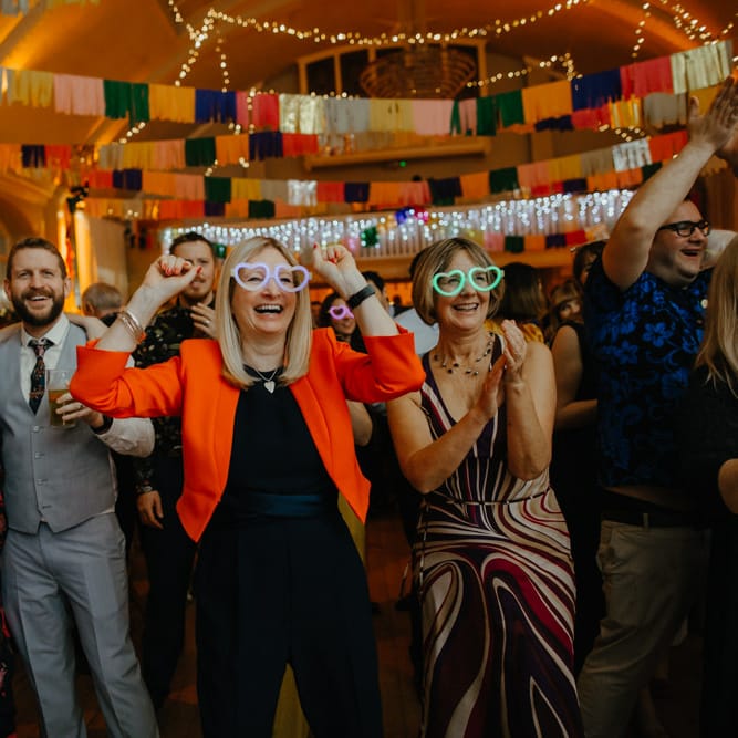 Wedding guests in neon glasses for Elton John tribute act wedding entertainment 