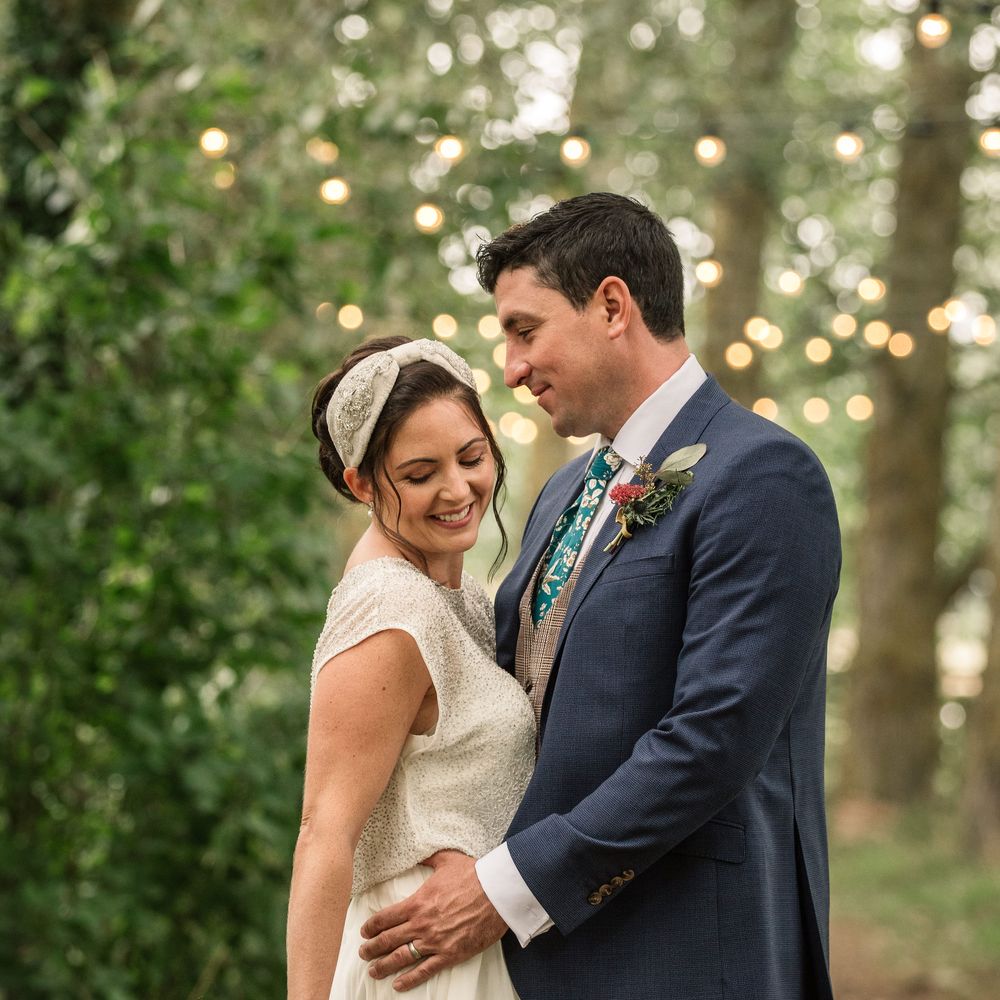 Bride & groom stand together outdoors 