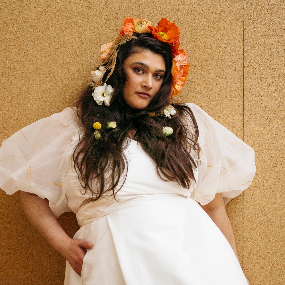 Bride wearing bridal separates with pocket maxi skirt, and sheer puff sleeve top
