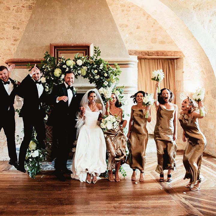 Bride & groom stand with their wedding party on wedding day