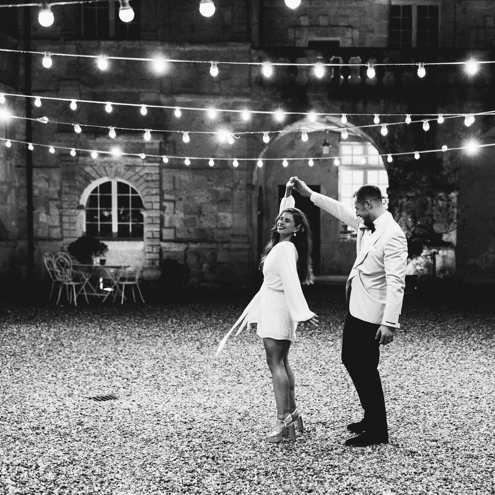 Groom spins his bride around in short white wedding dress 