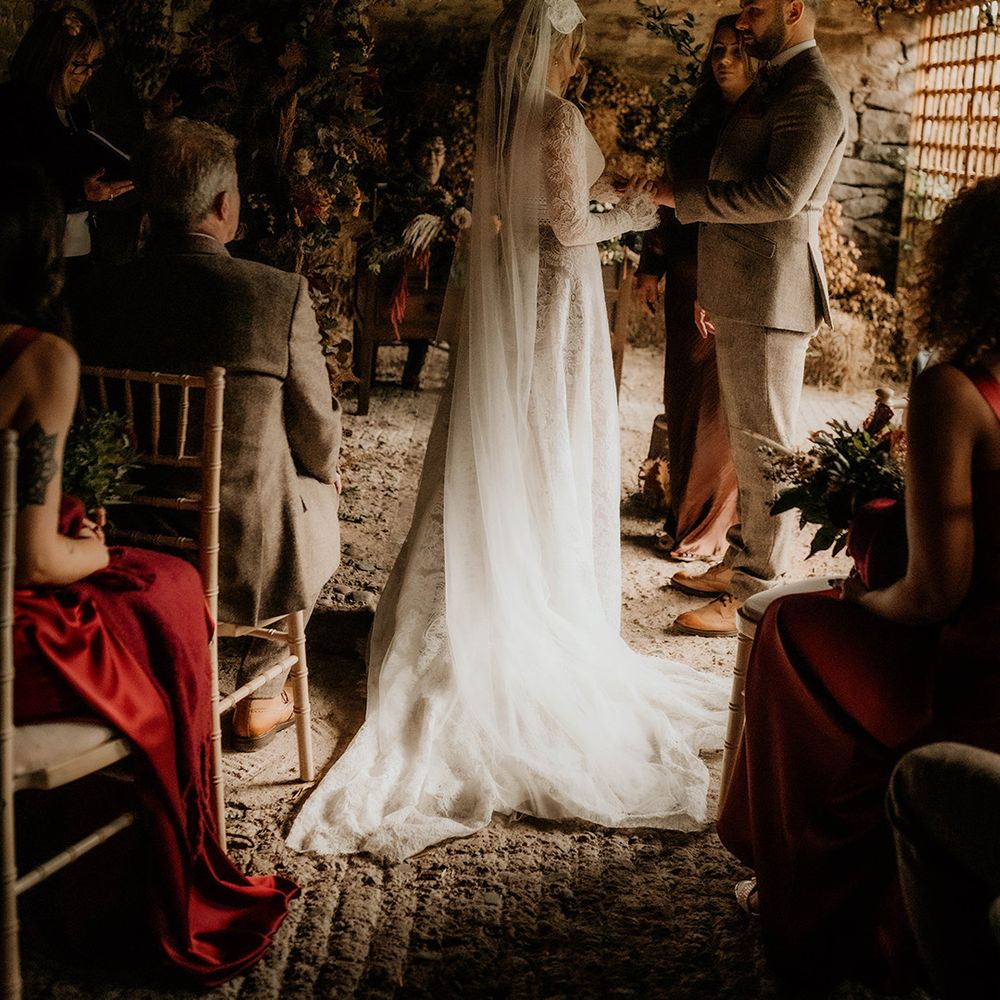 Lyde Court wedding ceremony with autumnal flowers and bride in a lace wedding dress and cathedral length Juliet cap veil 