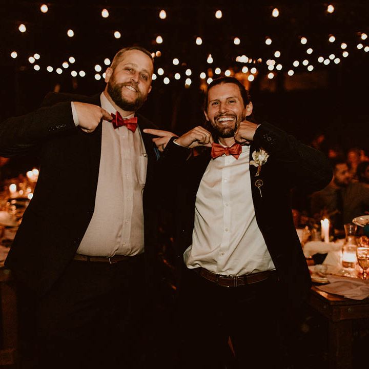 Groom smiles and laughs with wedding guest 
