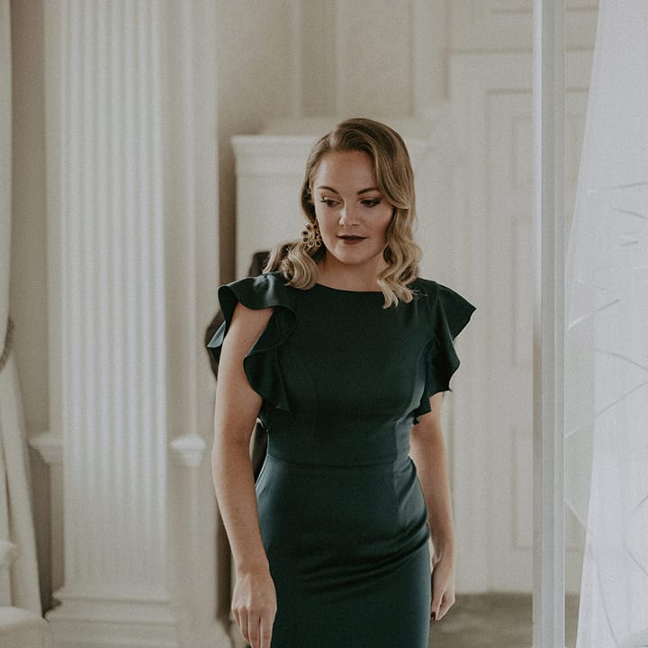 Bridesmaid in short sleeved dark bottle green high neck bridesmaid dress