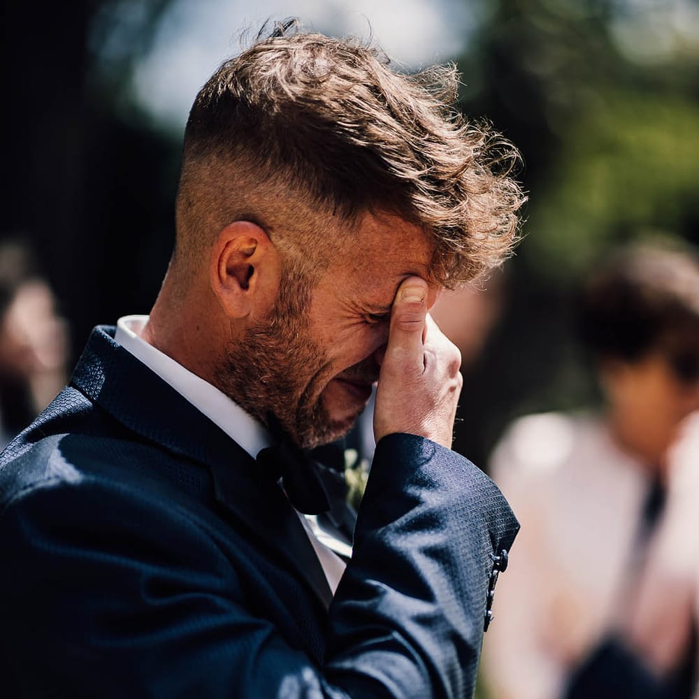 Groom covers his face as he starts crying when he sees the bride 