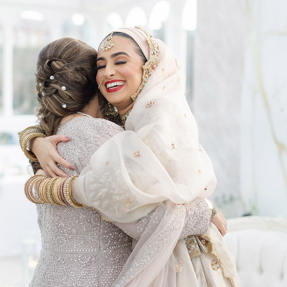Bride hugs friend on her wedding day at the Isla Gladstone Conservatory