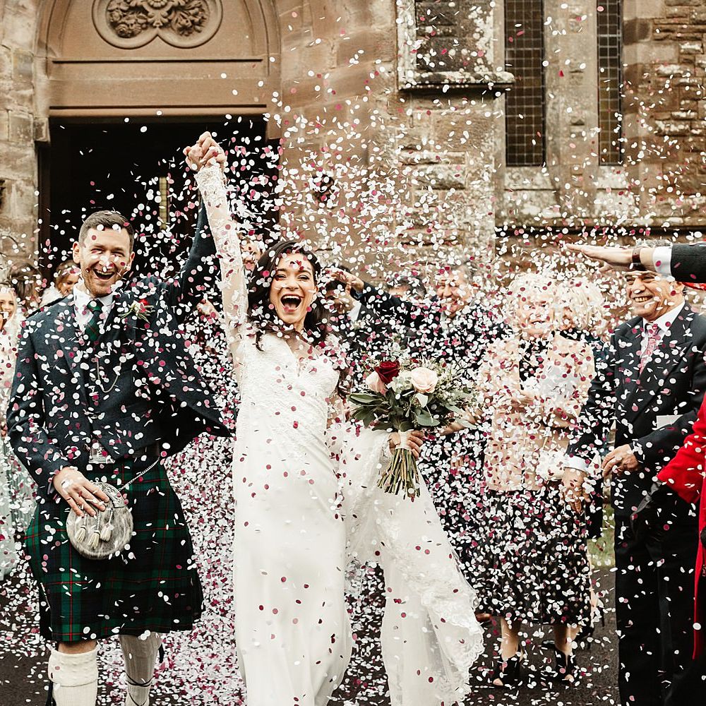 Bride & groom walk through confetti after wedding ceremony in Scotland 