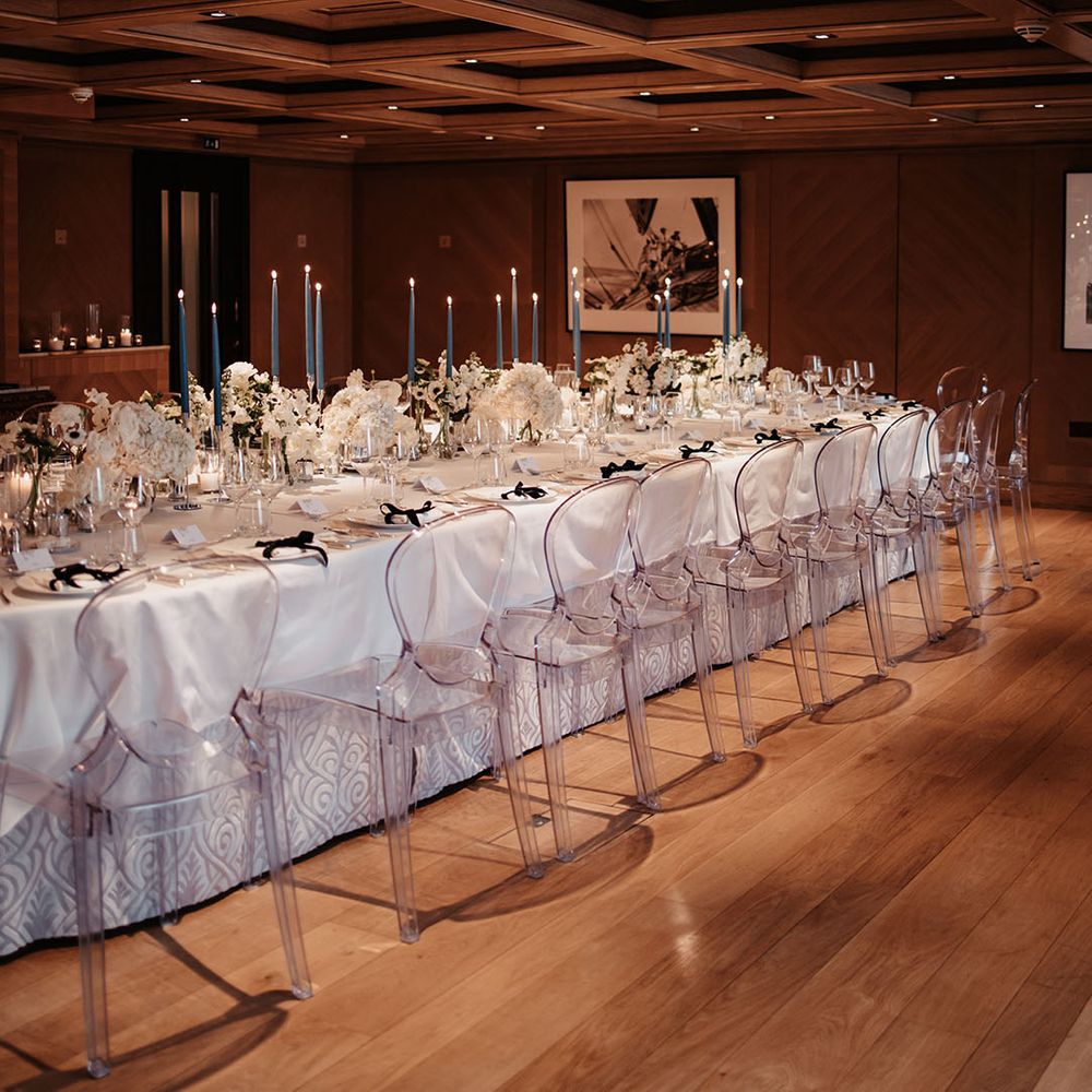Classic wedding table setting with white roses and grey and blue taper candles 