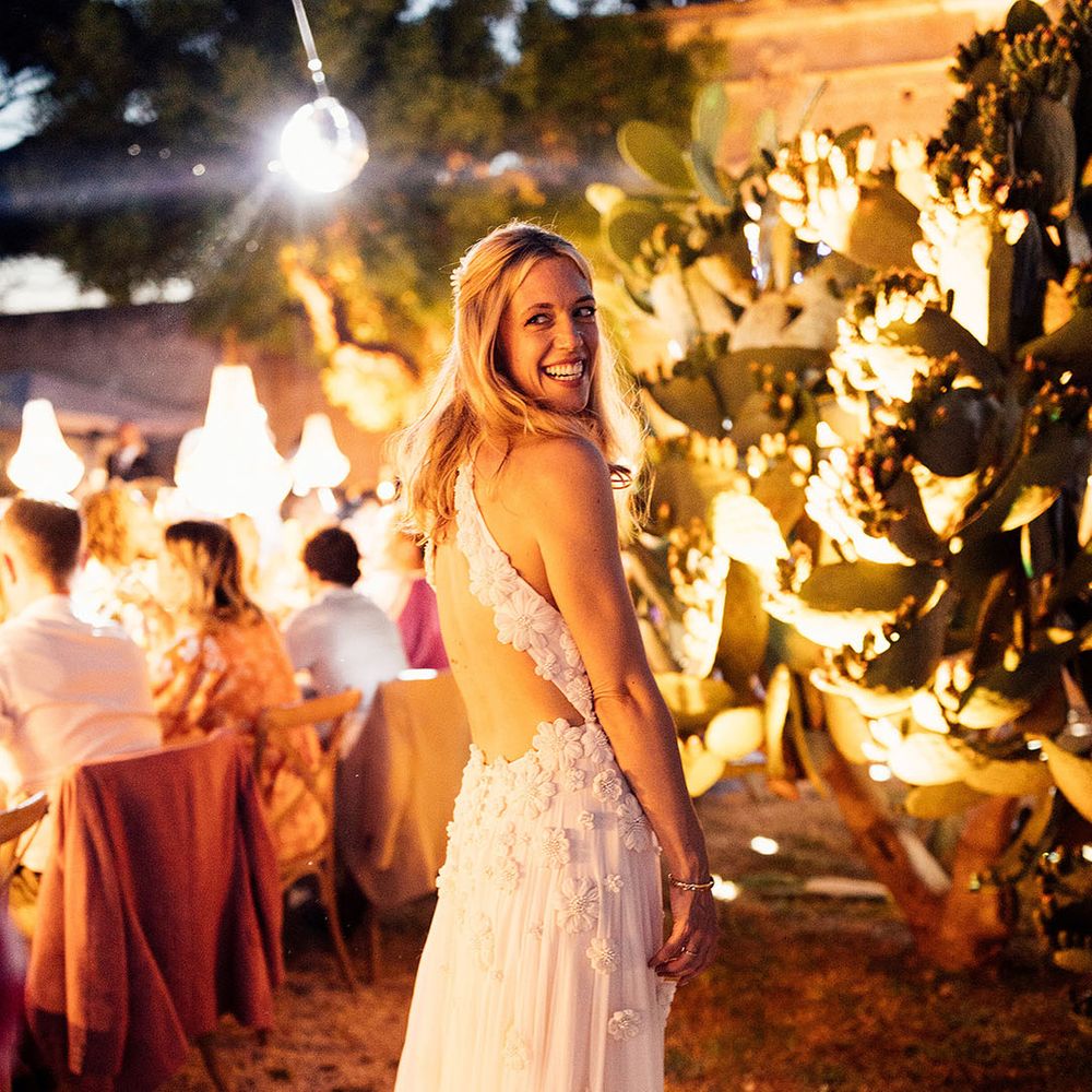 Bride with her blonde hair in a half up half down style in an Emma Beaumont flower halter neck wedding dress